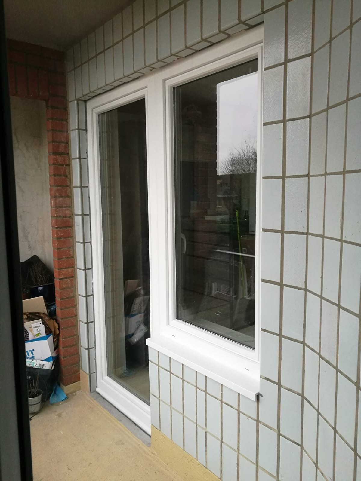 Porte d'entrée et châssis sur mesure installés sur une habitation bruxelloise par Élite Châssis