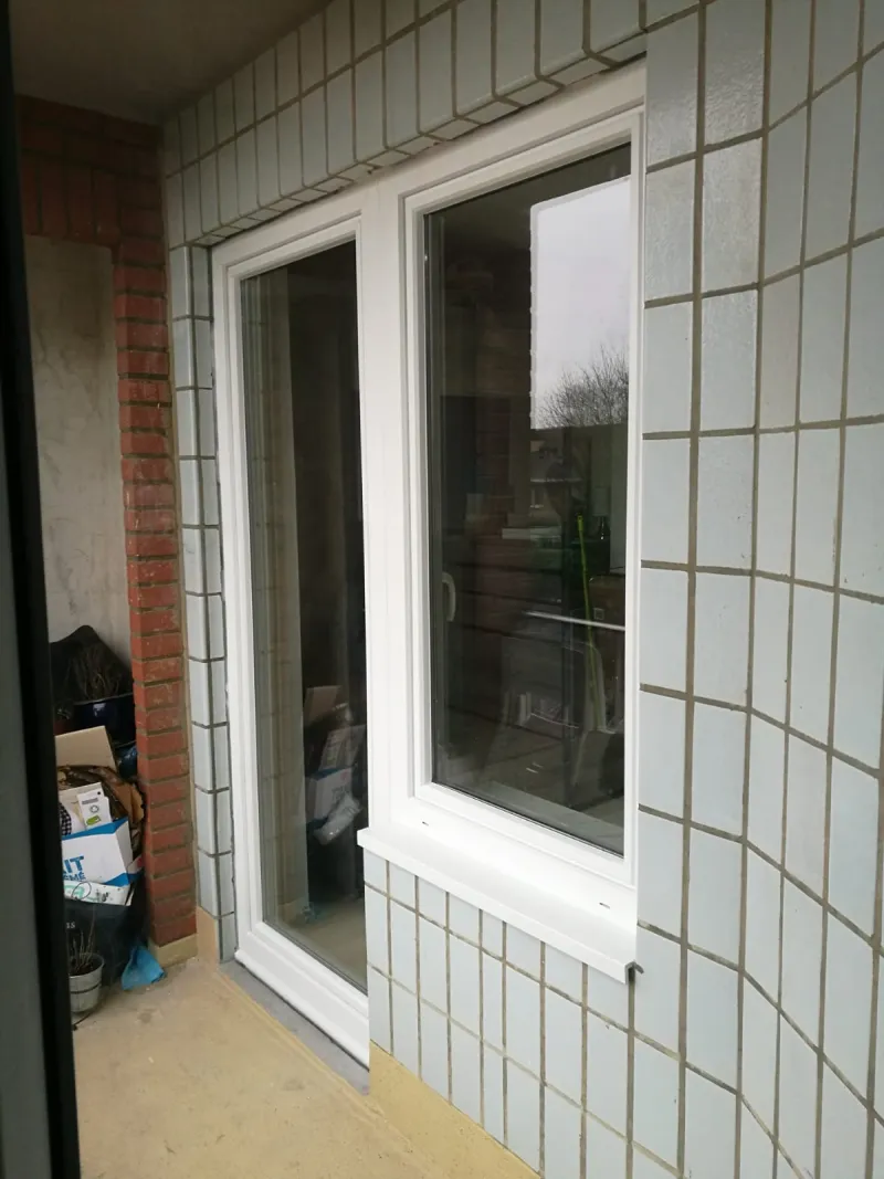 Porte-fenêtre et fenêtre en PVC blanc sur mesure installées sur une habitation bruxelloise par Élite Châssis