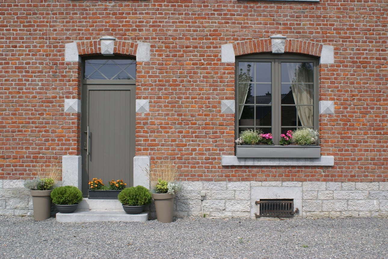 Porte d'entrée et fenêtre en menuiserie coordonnée sur une façade en brique, par Chassis 2000