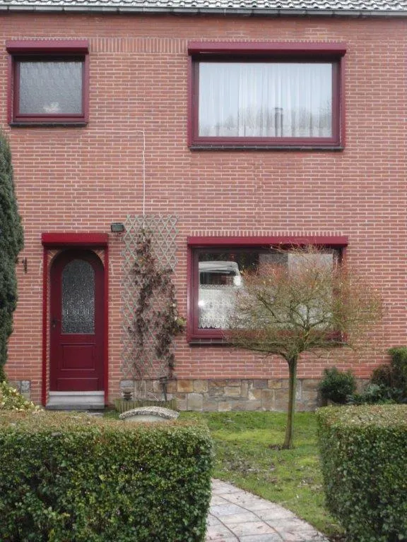 Châssis et porte en PVC teinte bordeaux sur une maison en rangée du bassin de Charleroi, réalisation FT Châssis