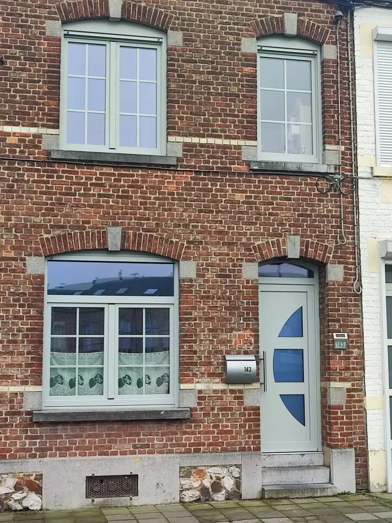 Châssis PVC gris clair et porte vitrée posés sur une maison ouvrière en rangée à Charleroi, par Menuiserie Kenan