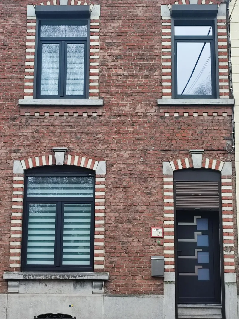 Fenêtres et porte d'entrée anthracite sur une maison en brique à Charleroi, par Menuiserie Kenan