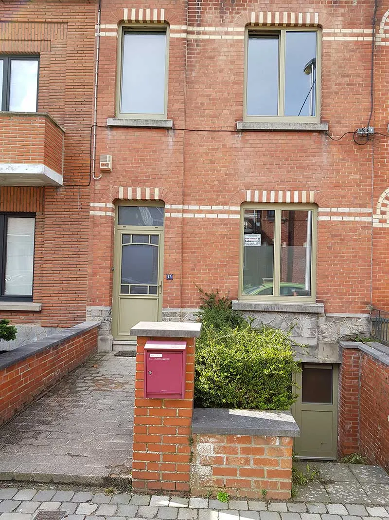 Châssis et porte d'entrée teinte olive sur une maison ouvrière en rangée du Centre, réalisation Menuiserie Audain & Fils