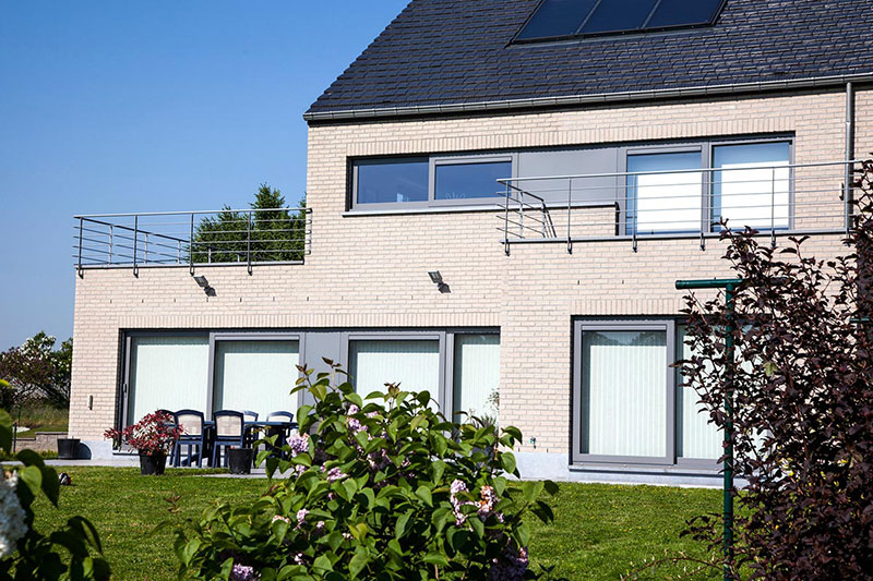Châssis et baies vitrées anthracite en bandeau sur une villa contemporaine en brique claire, réalisation Menuiserie Balasse