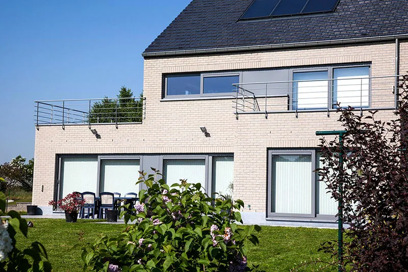Châssis et baies vitrées anthracite en bandeau sur une villa contemporaine en brique claire, réalisation Menuiserie Balasse