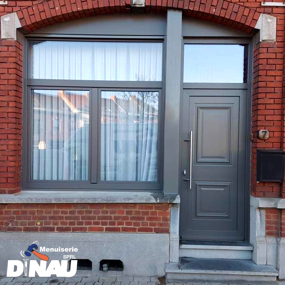Porte d'entrée anthracite, fenêtre et imposte vitrée sous arc en brique sur une maison en rangée de La Louvière, par Menuiserie Dinau