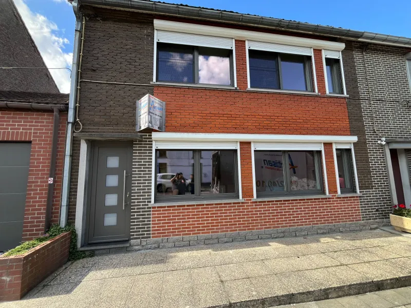 Fenêtres blanches en PVC et porte grise sur une maison en rangée en brique de la région de Mons, par Artisan du Châssis