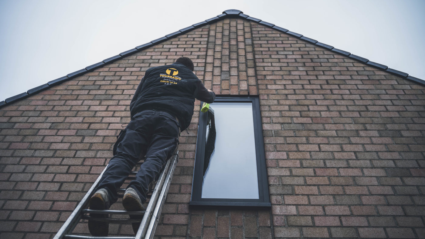 Châssis anthracite installé sur un pignon en brique d'une maison montoise, réalisation Menuiserie Toussaint à Mons