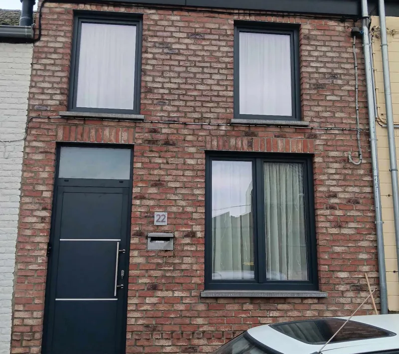 Châssis anthracite et porte d'entrée posés sur une maison de ville en brique du Borinage, réalisation Châssis Valency près de Mons
