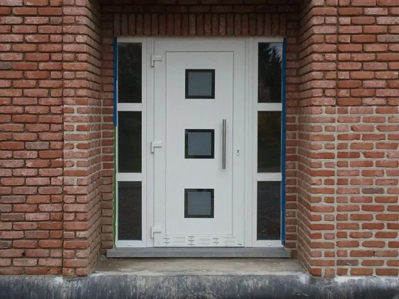Porte d'entrée en PVC blanc avec parties vitrées latérales, posée par Pro-Fenêtres dans la région de Charleroi