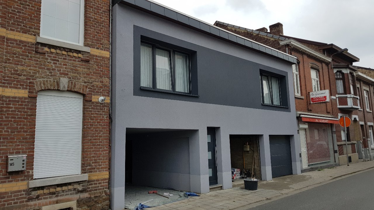 Fenêtres et porte anthracite sur une façade rénovée entre deux maisons en rangée en brique, réalisation UDM Châssis à Seraing