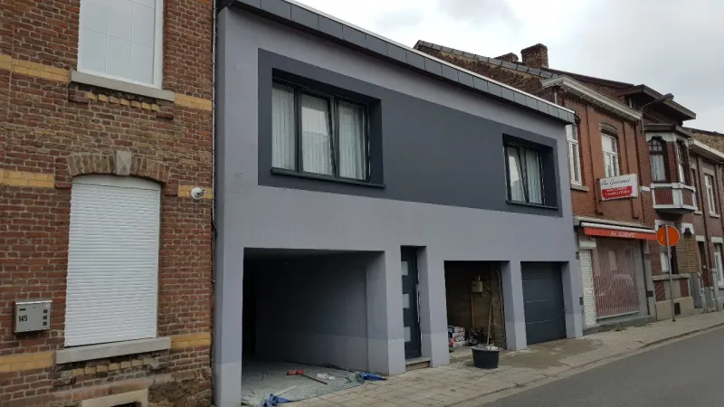 Fenêtres et porte anthracite sur une façade rénovée entre deux maisons en rangée en brique, réalisation UDM Châssis à Seraing