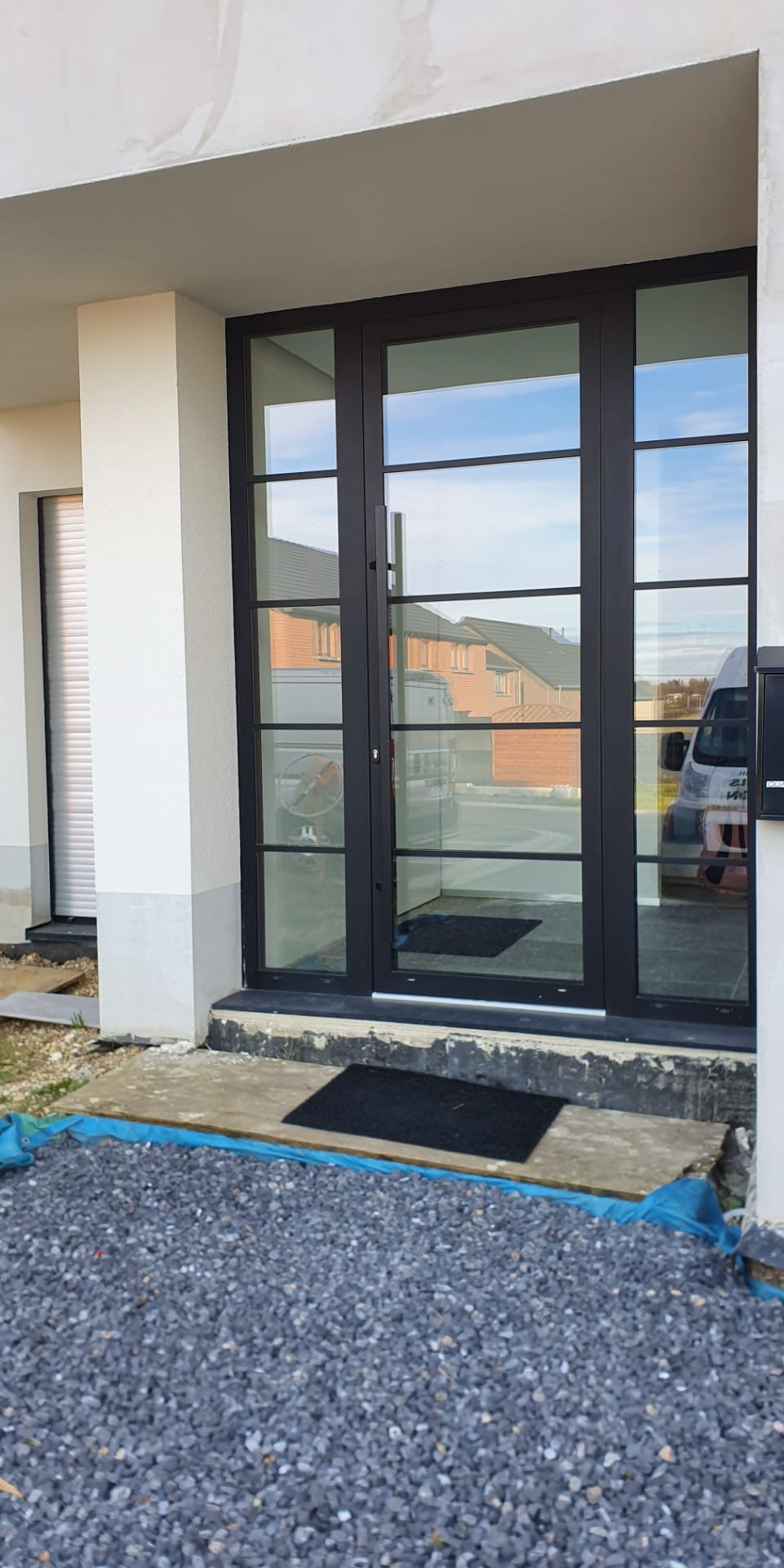 Porte d'entrée en aluminium anthracite avec parties vitrées latérales, réalisation UDM Châssis à Seraing