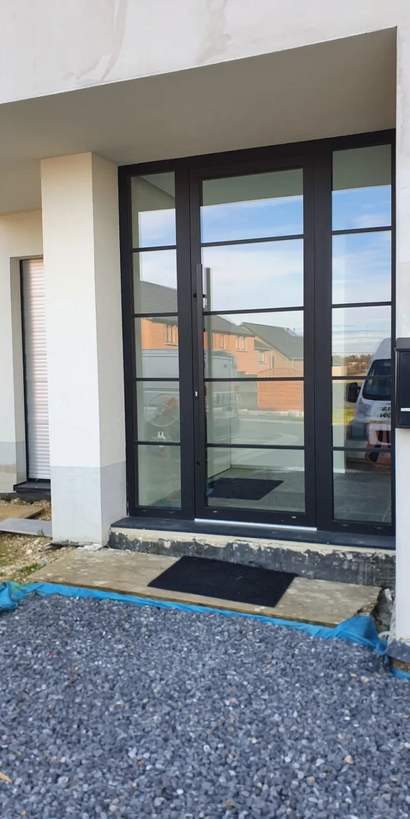 Porte d'entrée en aluminium anthracite avec parties vitrées latérales, réalisation UDM Châssis à Seraing