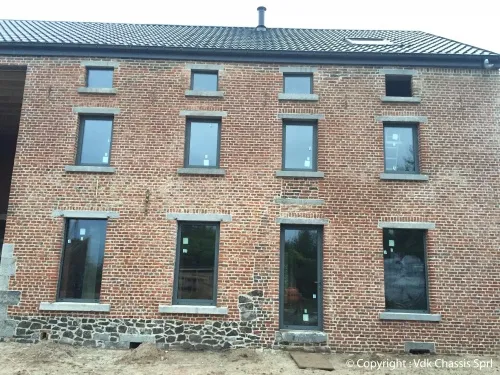 Châssis neufs posés sur une maison en brique en rénovation, réalisation VDK Châssis en région liégeoise