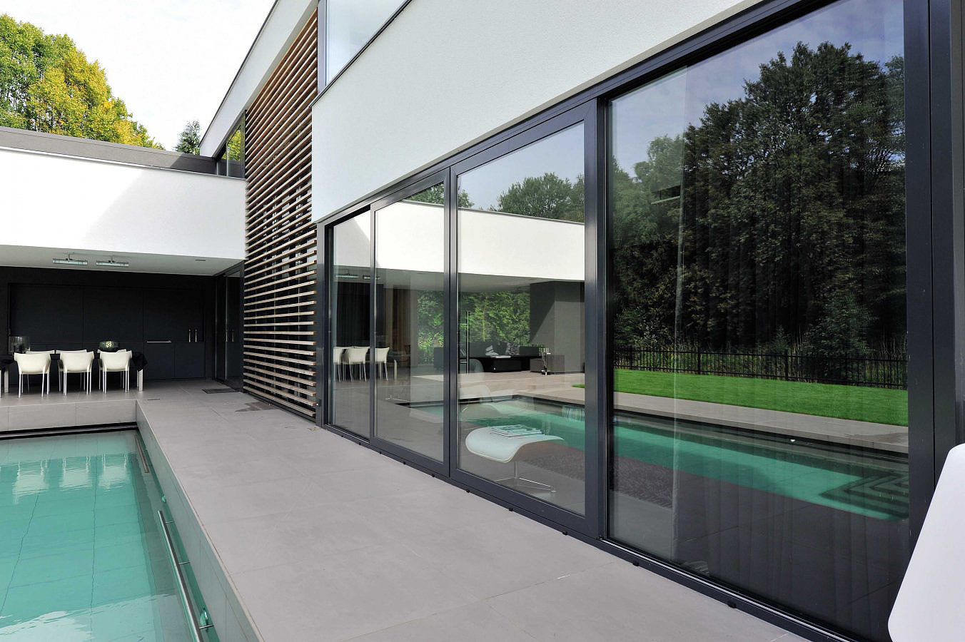 Grandes baies coulissantes en aluminium noir sur une villa contemporaine avec piscine, réalisation Nikal Châssis à Waterloo