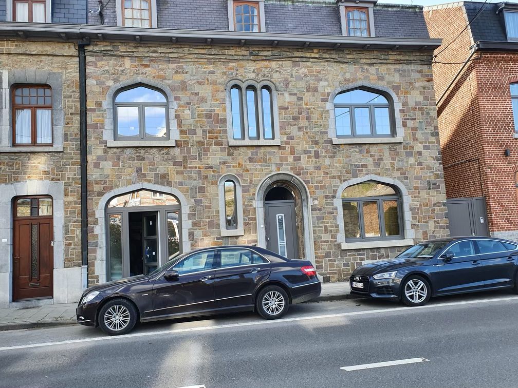 Fenêtres cintrées anthracite et porte d'entrée sur une maison de maître en pierre, réalisation Chassis Protech dans le Brabant wallon