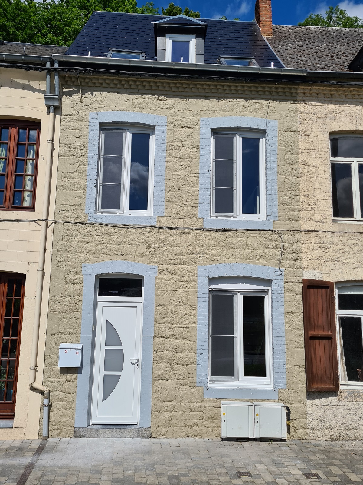Façade de maison de ville en pierre avec fenêtres PVC blanches et porte d'entrée vitrée, réalisation Menuiserie MGPC près de Wavre