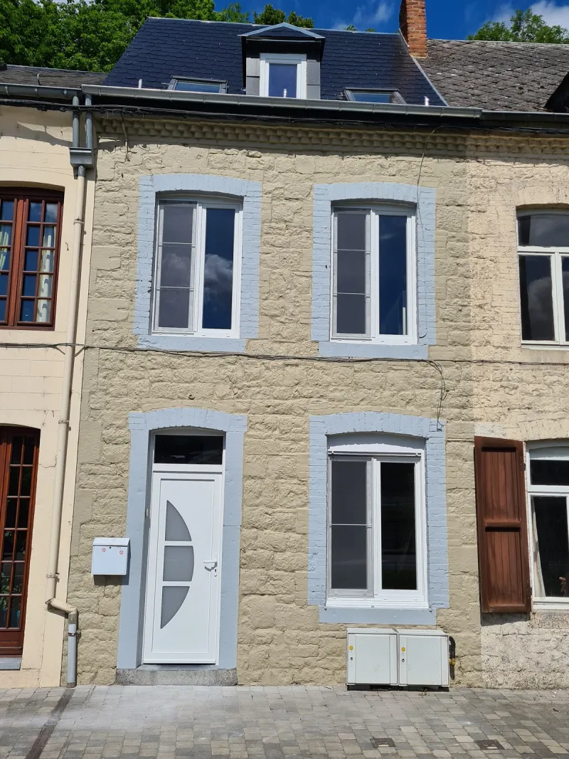 Façade de maison de ville en pierre avec fenêtres PVC blanches et porte d'entrée vitrée, réalisation Menuiserie MGPC près de Wavre
