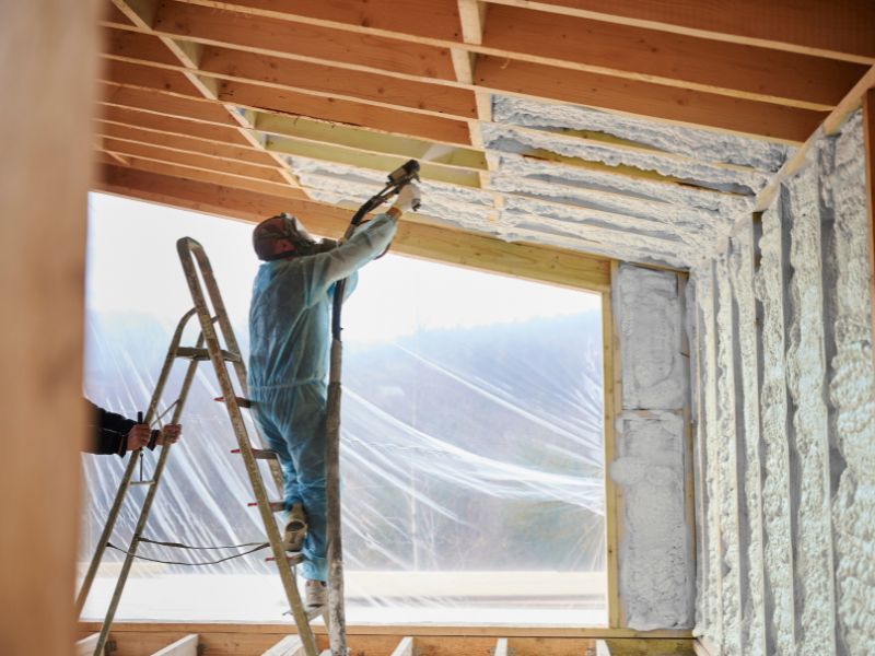 Isolation par projection de polyuréthane autour d'une baie vitrée en cours de chantier