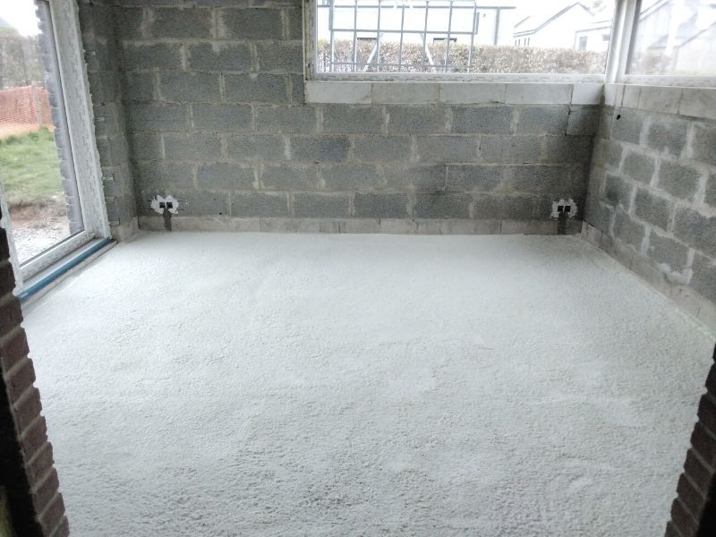 Mousse polyuréthane projetée sur la dalle d'une pièce aux murs en blocs