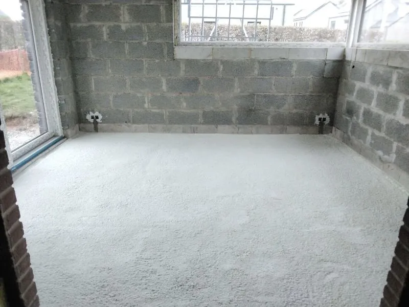 Mousse polyuréthane projetée sur la dalle d'une pièce aux murs en blocs