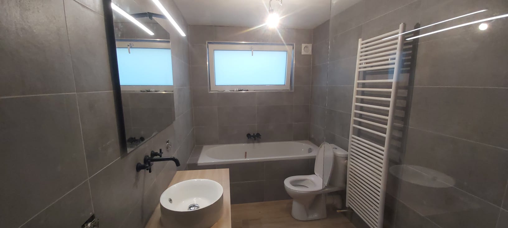 Salle de bain grise avec baignoire à Tournai, Zéphir Construction