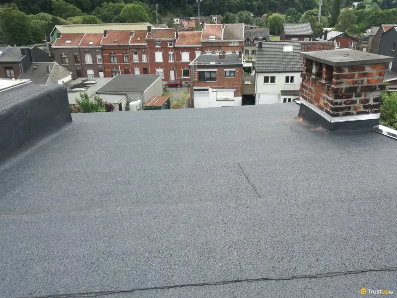 Vue panoramique sur les toits depuis une toiture plate en réfection avec souche de cheminée, par ARS Concept à Seraing