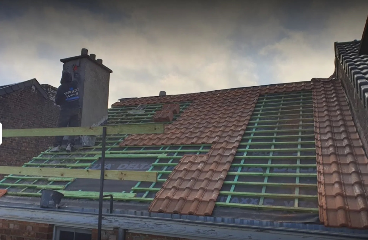 Toiture en cours de retuilage sur liteaux neufs avec souche de cheminée, par Bati Ergo