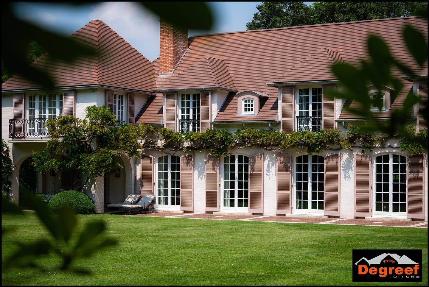 Grande toiture en tuiles à croupes et lucarnes d'une demeure de maître, par Toiture Degreef