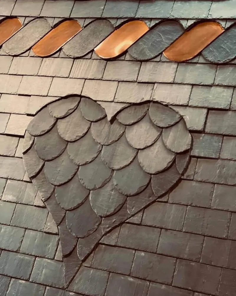 Détail d'ardoises posées en écaille avec motif décoratif et solins en cuivre, par Toiture Degreef