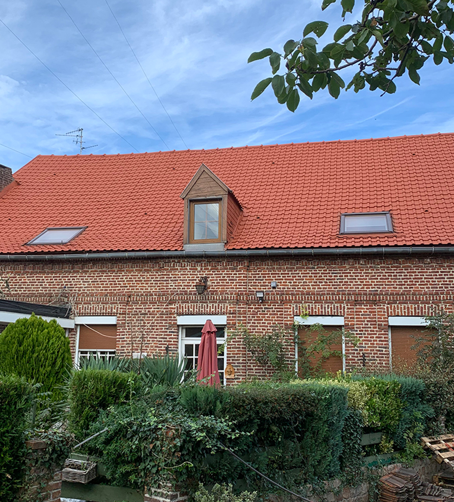 Toiture en tuiles terre cuite avec velux et lucarne sur une maison en briques, par Dubois Habitat à Tournai