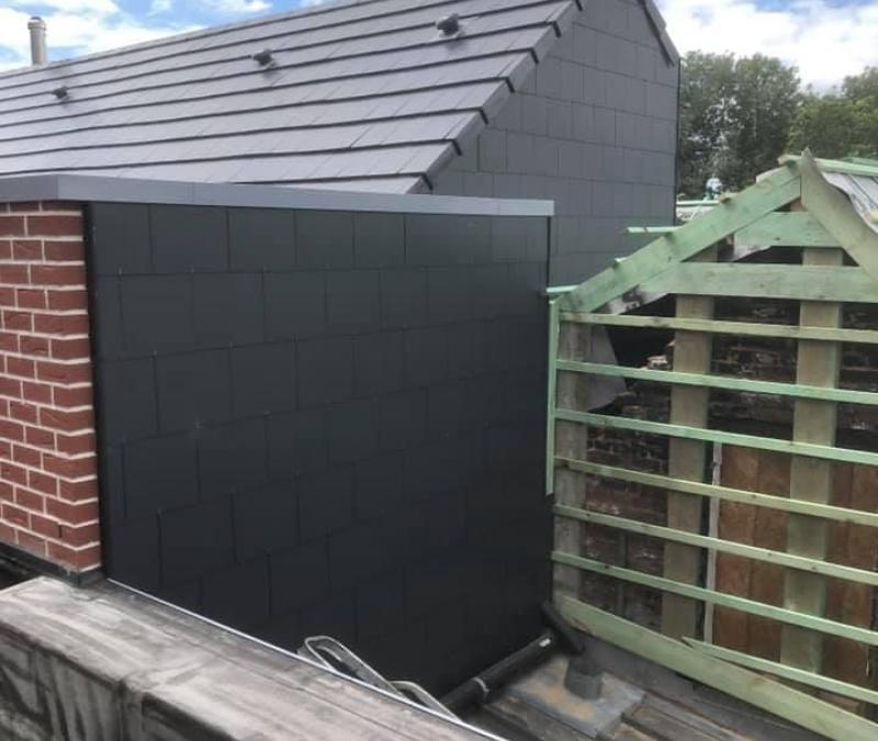 Bardage en ardoises anthracite et toiture en tuiles d'une extension, par Remy à Neuf à Nivelles