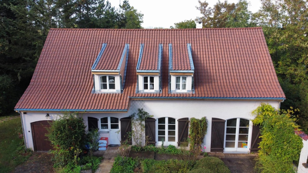 Toiture en tuiles à lucarnes sur une maison quatre façades par Toiture Roosens