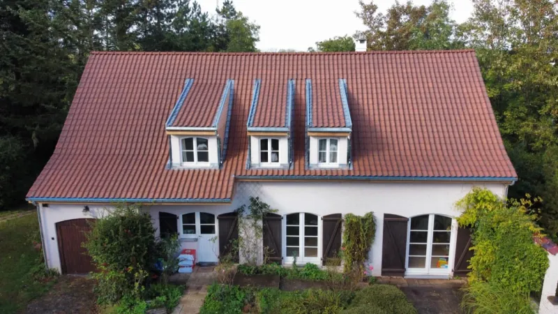 Toiture en tuiles à lucarnes sur une maison quatre façades par Toiture Roosens