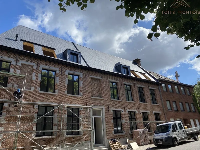 Rénovation de toiture en ardoises sur un bâtiment ancien réalisée par Toits Montois à Mons