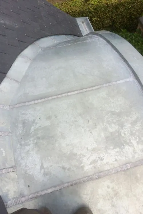 Habillage en zinc d'une baie arrondie sur une toiture schaerbeekoise, par Toitures Yakubs
