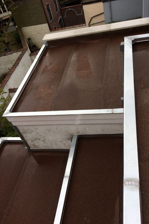 Toiture plate en roofing avec zinguerie et vue sur les toits schaerbeekois, par Toitures Yakubs